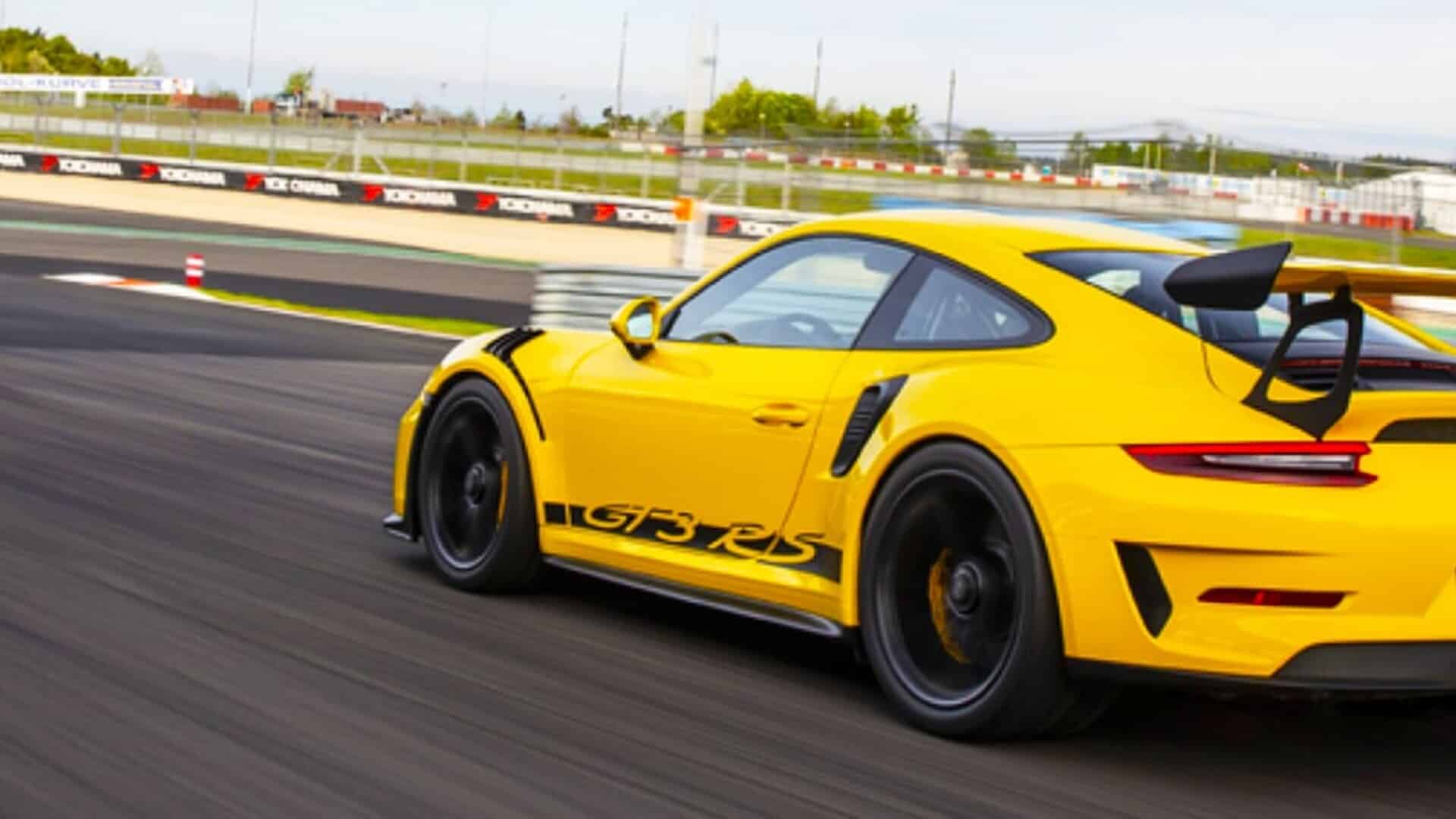 Porsche GT3 RS jaune en sortie de virage sur circuit